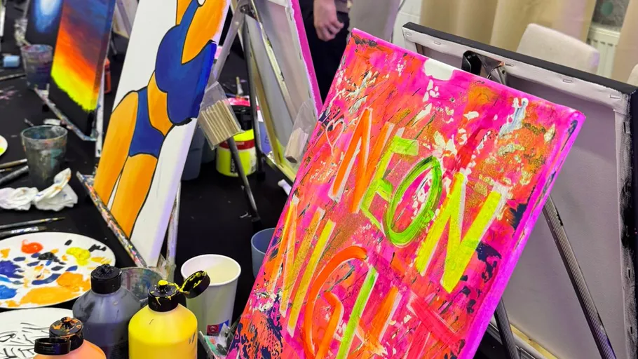Colorful paintings on easels in a studio.