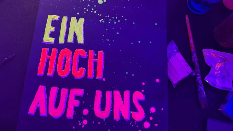 Bright text saying 'Ein Hoch Auf Uns' on canvas.