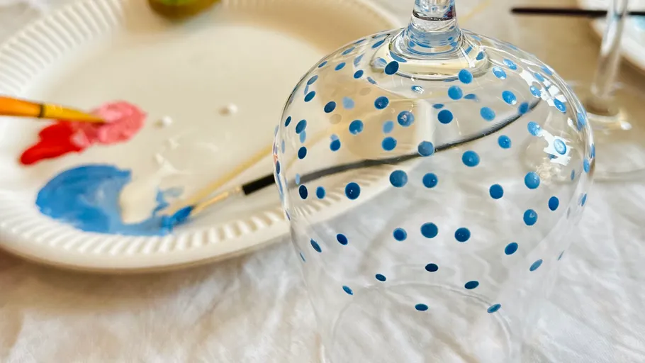 Painted wine glass beside paint palette.