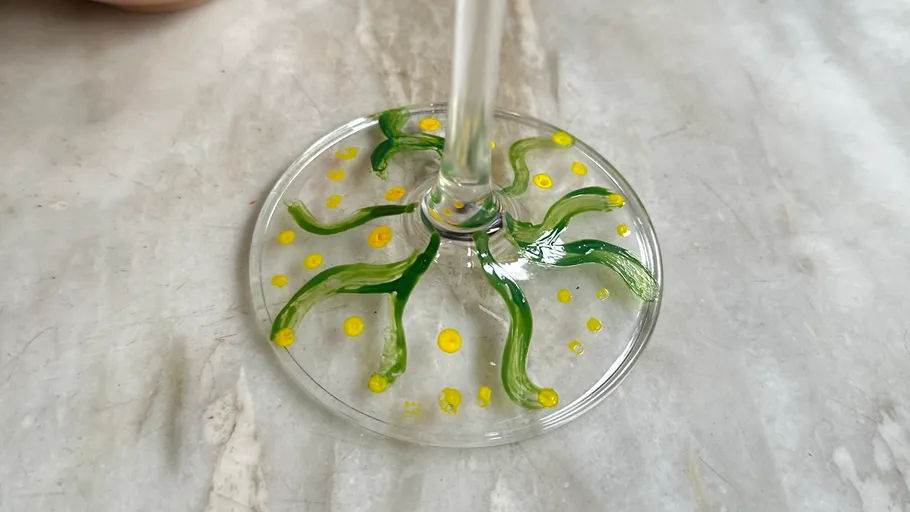 Glass base with green and yellow designs.