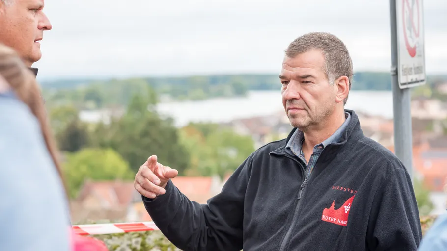Man gesturing while talking outdoors.