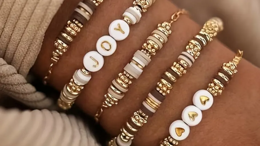 Armbänder mit Perlen und Buchstaben am Handgelenk.