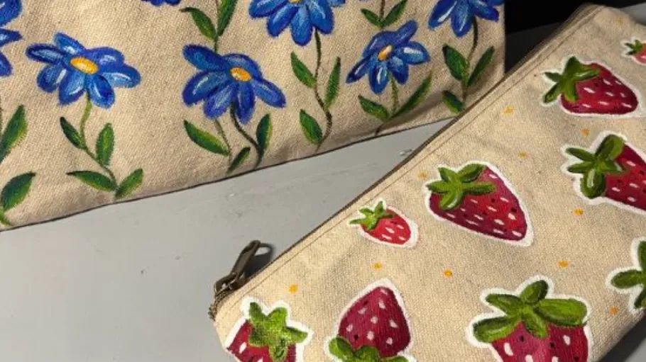 Zwei Leinwandtaschen mit bunten handgemalten Designs.