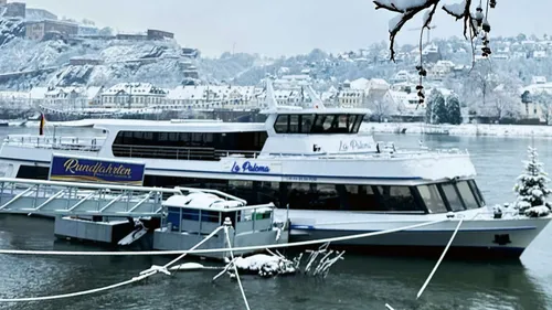 Touristenboot am verschneiten Flussufer angedockt.