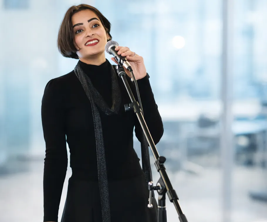 Woman singing into microphone in office.