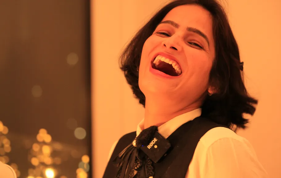 Woman laughing with blurred lights background.