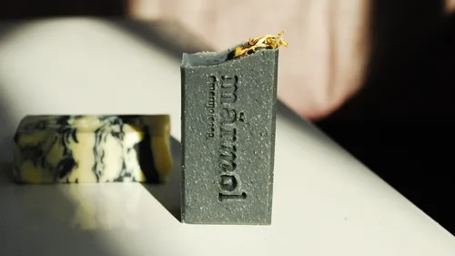 Two artisan soap bars on white surface.