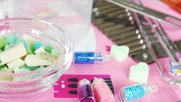Colorful craft supplies on a pink surface.