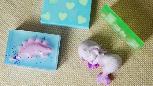 Colorful soaps with mermaid, dinosaur shapes.