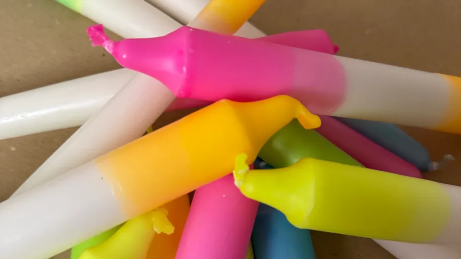 Colorful candles stacked on a surface.