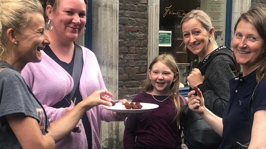 Group of people enjoying chocolate treats outside.