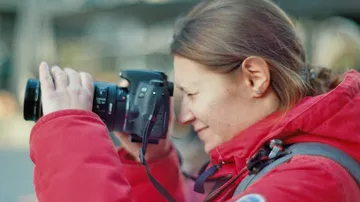 Frau in roter Jacke fotografiert im Freien.