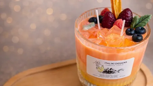 Kerze wie ein Fruchtcocktail auf Tisch.