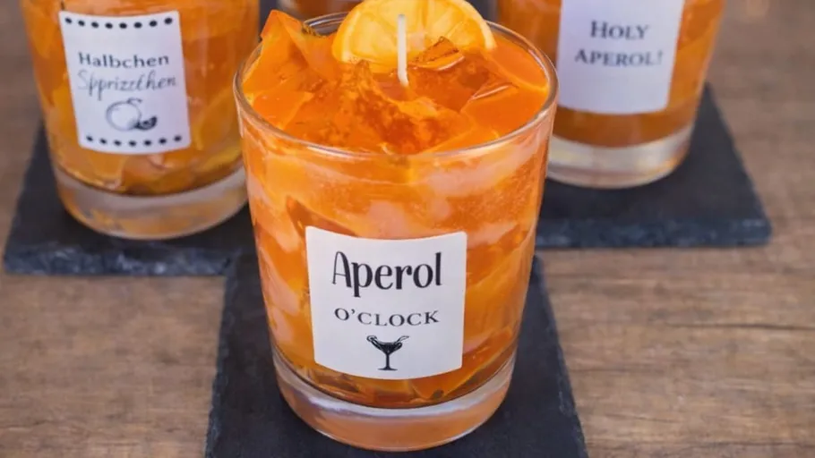 Three Aperol cocktails on dark coasters.