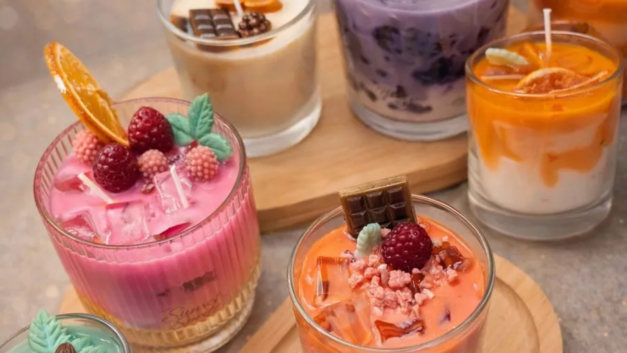 Colorful scented candles resembling desserts displayed.