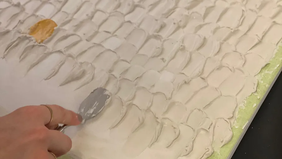 Hand verwendet Malmesser auf strukturiertem Leinwand.