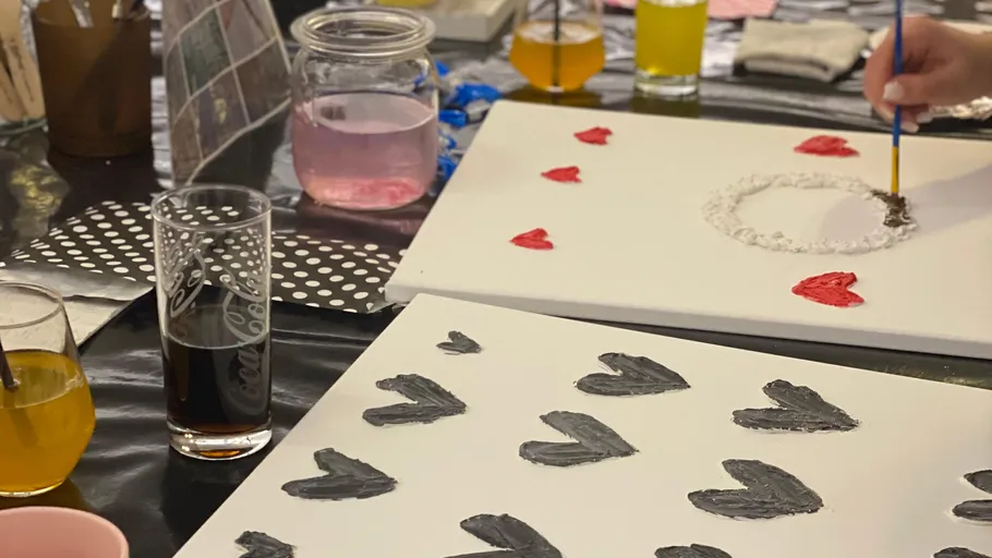 Canvases with heart paintings and drinks.