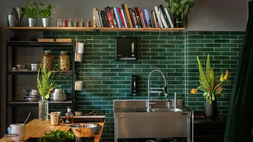 Modern kitchen with green tiles and sink.