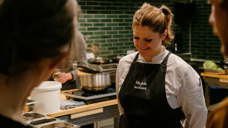 Chef smiling in kitchen conversation.