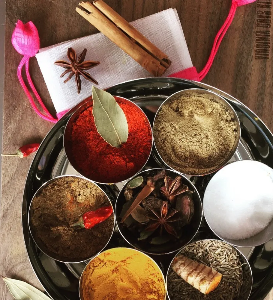 Spices in bowls on wooden surface.