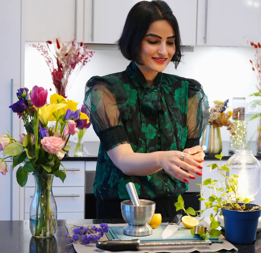 Woman preparing herbs in modern kitchen.