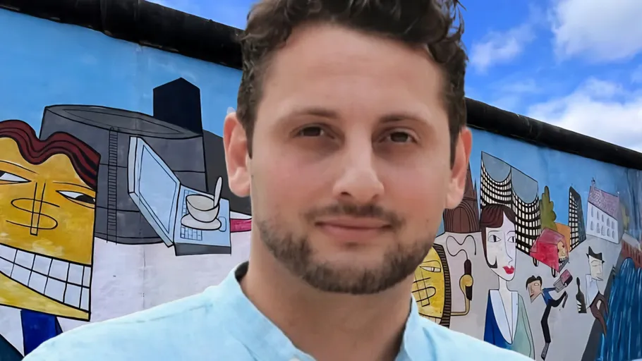Man standing in front of painted wall.