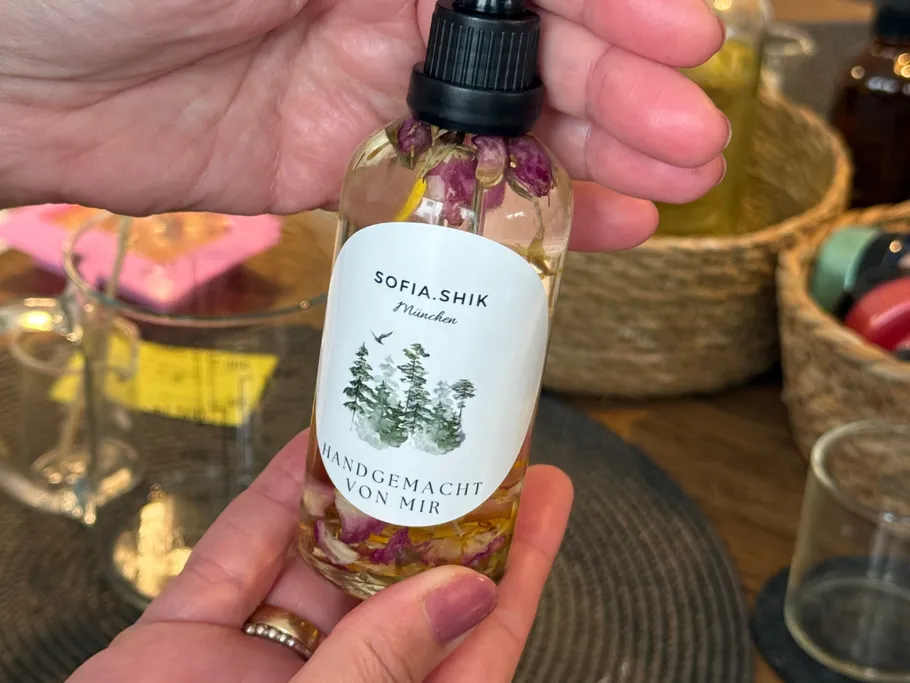 Hand holding a small bottle with flowers inside.