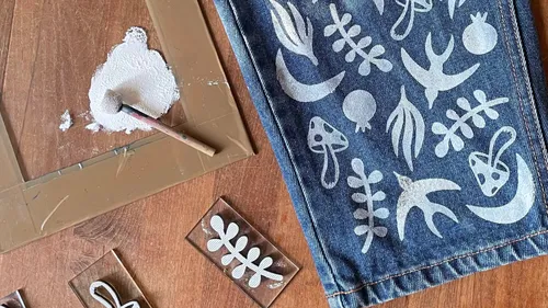 Denim mit weißen botanischen Designs bemalt.