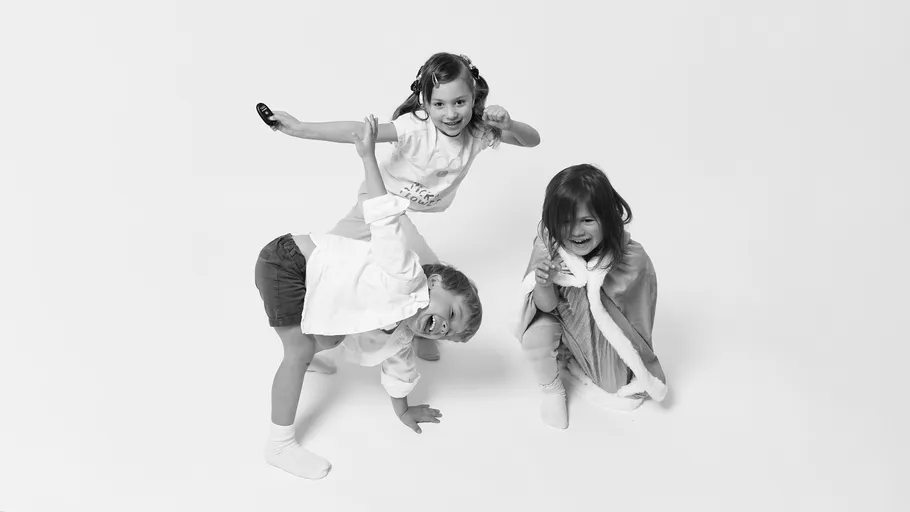 Three children posing playfully in a studio.