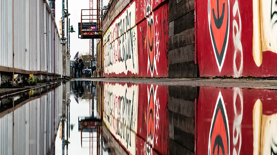 Graffiti-Wände in einer Pfütze gespiegelt.