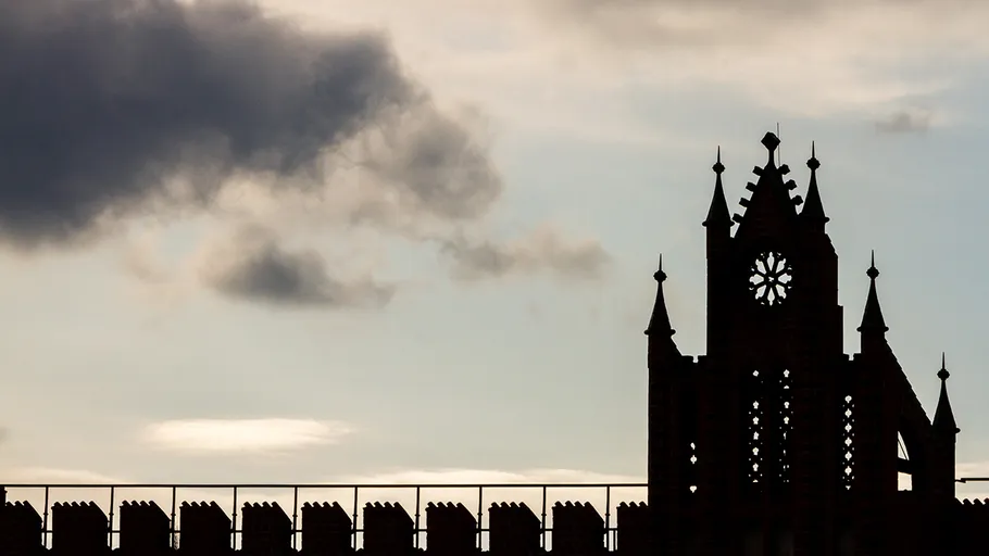 Kirchensilhouette vor wolkigem Himmel.
