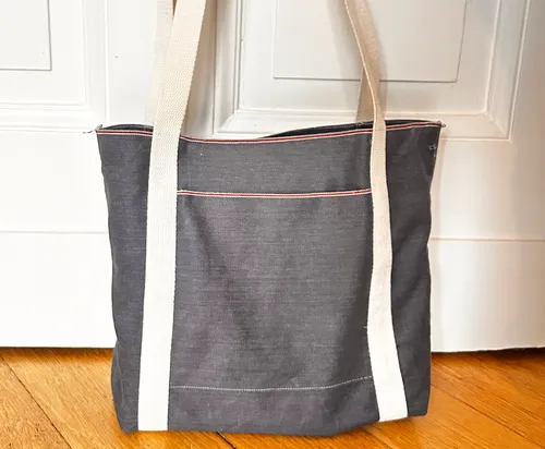 Gray tote bag on wooden floor.