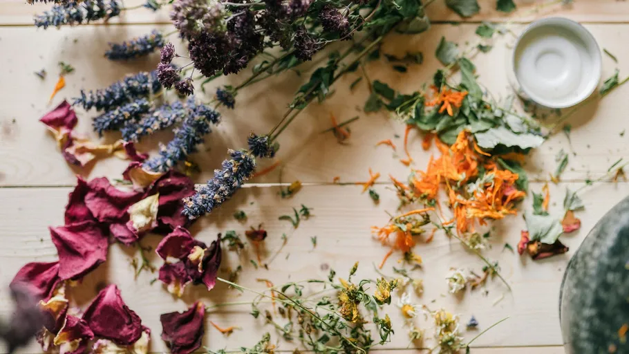 Dried flowers scattered on wooden table.