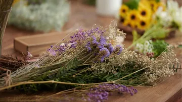 Getrocknete Blumen auf Holztisch arrangiert.