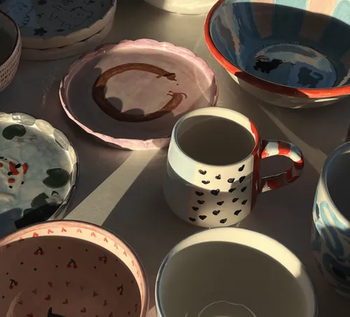 Keramikgeschirr und Tassen im Sonnenlicht.