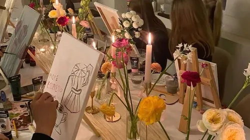 People painting at a candlelit art class.