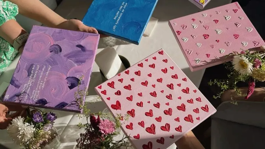 People holding colorful heart and pattern notebooks.