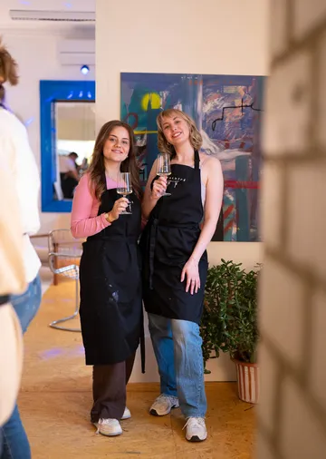 Zwei Frauen halten Weingläser im Innenraum