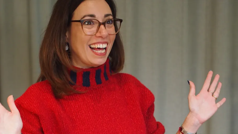 Smiling woman wearing glasses in red sweater.