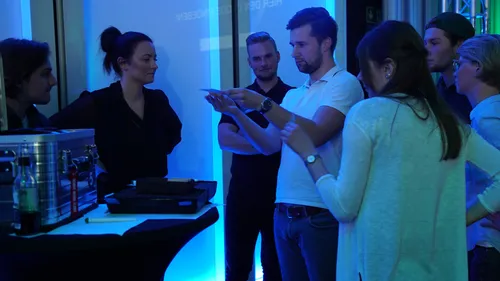 Group gathered around table, discussing something.