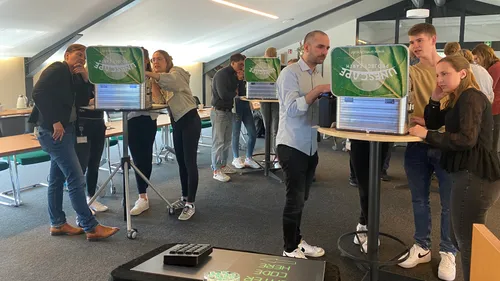 Menschen lösen Rätsel gemeinsam in Raum.