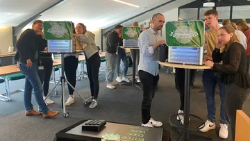 People solving challenges at tables indoors.