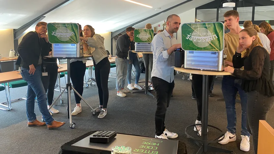 People solving challenges at tables indoors.