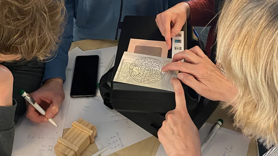 Personen lösen ein Puzzle am Tisch.