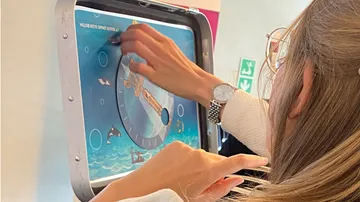 Person interacting with a puzzle on the wall.