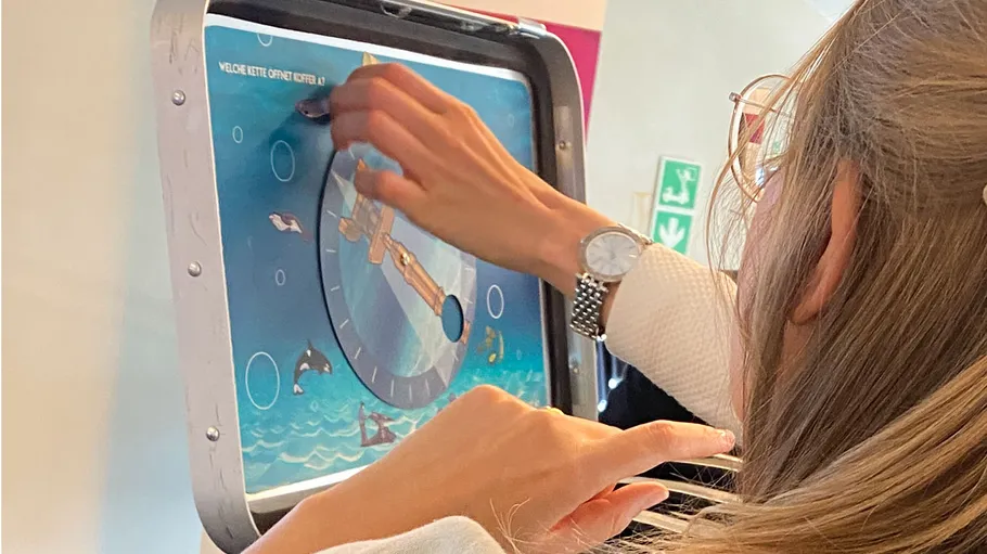 Woman playing interactive wall game indoors.