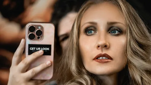 Frau macht Selfie mit Smartphone drinnen.