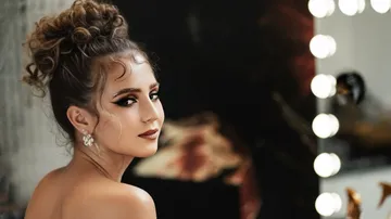 Woman with elegant hairstyle, makeup in a studio.