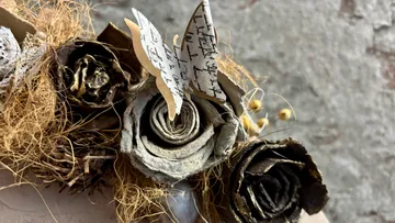 Paper roses and butterfly with handwritten text.