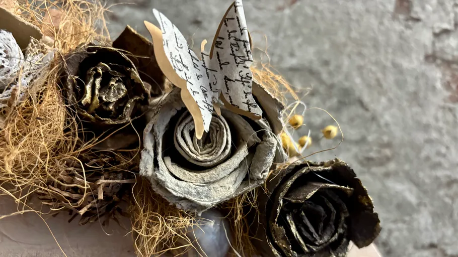 Paper roses and butterfly with handwritten text.